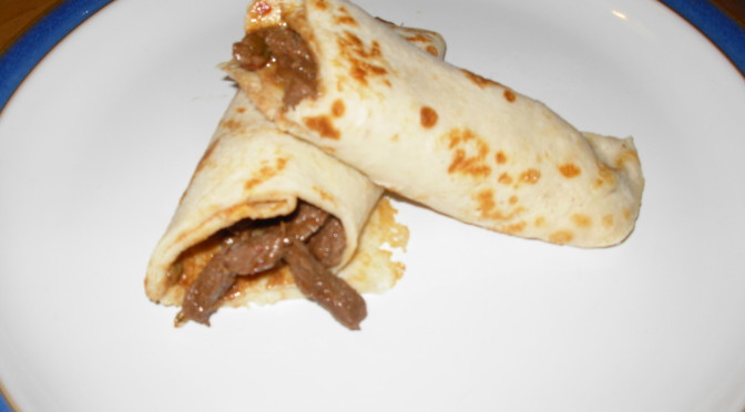 rolled pancake cut in half to show chilli beef filling inside