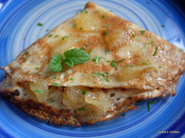 Pancake folded into quarter circle, topped with lemon syrup and mint